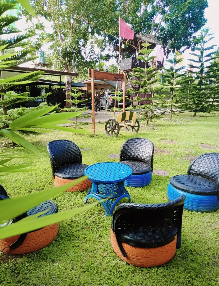 Colourful upcycled tyre chairs around a table on the lawn